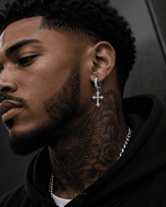 

Close-up of a stylish Black man wearing silver stainless steel cross hoop earrings with sparkling cubic zirconia stones, luxury men's streetwear jewelry, detailed side profile, modern fashion accessory.