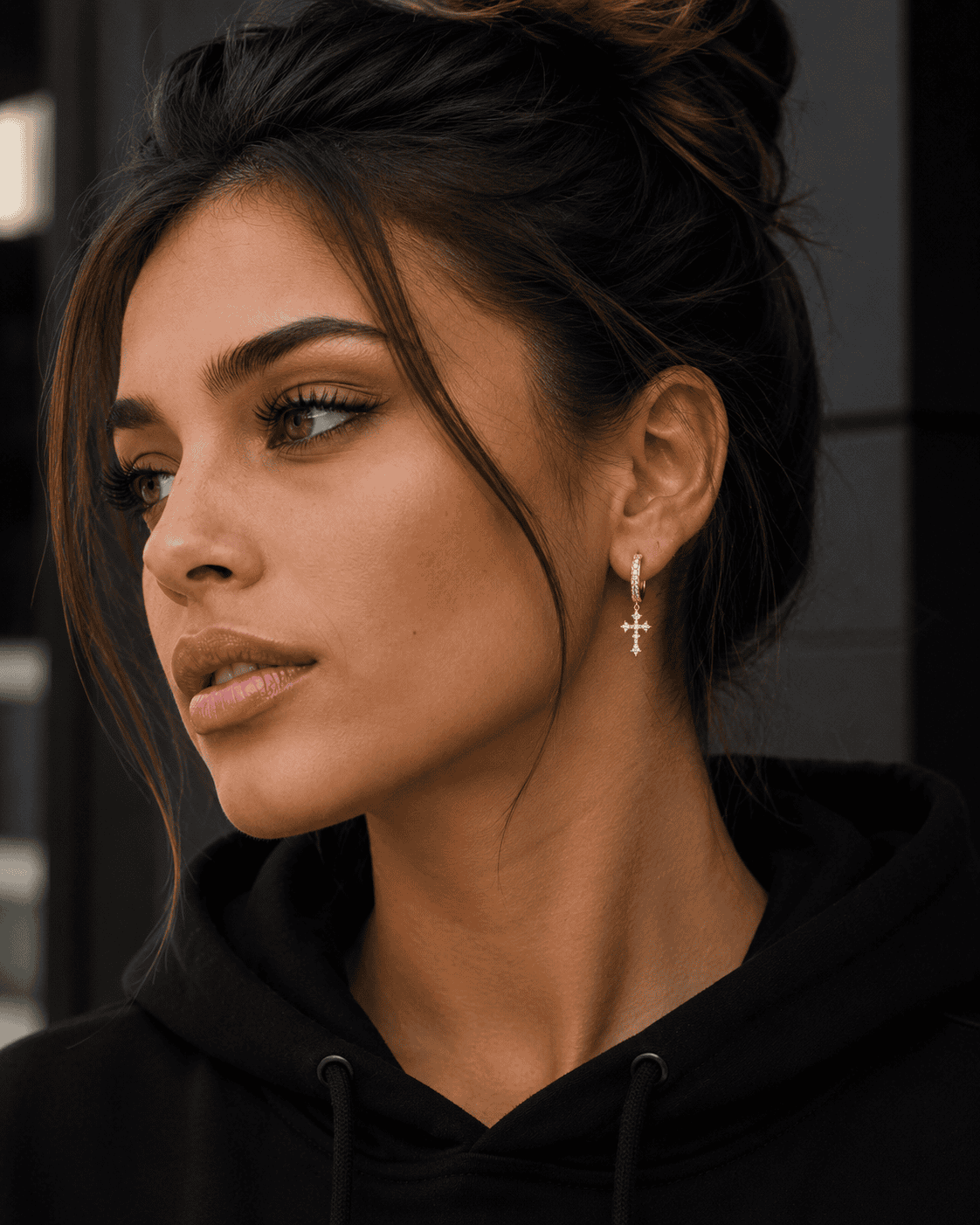Close-up of a stylish Black man wearing silver stainless steel cross hoop earrings with sparkling cubic zirconia stones, luxury men's streetwear jewelry, detailed side profile, modern fashion accessory.